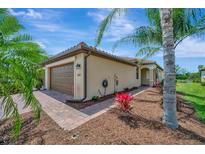 Home exterior with landscaping and a two car garage with a brick paver driveway and red tiled roof at 6642 Willowshire Way, Bradenton, FL 34212