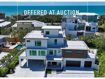 Stunning three-story beach house featuring modern design, a flat roof, and a spacious two-car garage at 8800 Midnight Pass Rd, Sarasota, FL 34242