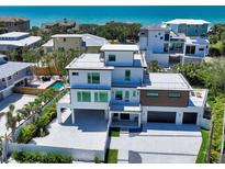 Contemporary three-story home featuring multiple balconies, a two-car garage, and views of the ocean at 8800 Midnight Pass Rd, Sarasota, FL 34242