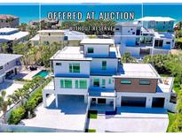 Stunning three-story home with a rooftop deck and modern architectural design, located near a beautiful beach at 8800 Midnight Pass Rd, Sarasota, FL 34242