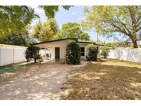 Charming single-story home with a flat roof and well-maintained landscaping and a white fence at 1018 Charlotte Ave, Sarasota, FL 34237