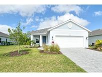 Charming one-story home features a manicured lawn, gray roof, neutral paint, and a two-car garage at 18249 Vizcaya Ct, Venice, FL 34293