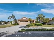 Charming single-story home featuring lush landscaping, a tile roof, and an attached two-car garage at 3835 Alamanda Dr, Sarasota, FL 34238