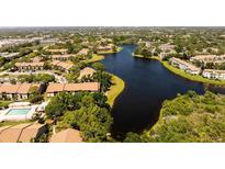 An aerial view of community homes surrounding a beautiful, winding lake at 4061 Crockers Lake Blvd # 2618, Sarasota, FL 34238