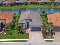 Stunning aerial view of a well-maintained home on a waterfront lot with lush landscaping at 4726 Zeno Ct, Bradenton, FL 34211
