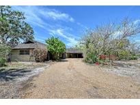 Charming home with a gravel driveway and mature landscaping offering a serene setting at 5502 Shadow Lawn Dr, Sarasota, FL 34242
