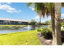 Scenic view of the condo building overlooking the lake with water fountains under a sunny sky at 5624 Ashton Lake Dr # 5624, Sarasota, FL 34231