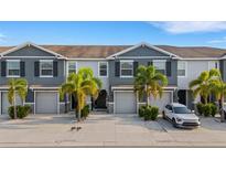 Charming townhomes featuring gray exteriors, well-manicured landscaping, and inviting front entrances, showcasing curb appeal at 6516 Serenity Fall Ln, Sarasota, FL 34240