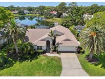 An aerial view of a lakeside home with lush landscaping, a screened in pool and a view of the lake at 8146 Shadow Pine Way, Sarasota, FL 34238