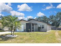 Charming single-story home featuring a screened porch, attached garage, and well-maintained lawn under a bright blue sky at 1011 Bacon Ave, Sarasota, FL 34232