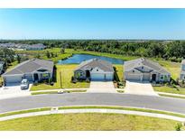 Beautiful single-story homes with well-manicured lawns, long driveways, and a tranquil pond in the background at 17555 Cantarina Cv, Bradenton, FL 34211