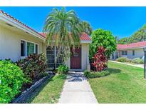 Charming home featuring a beautiful red tile roof, lush tropical landscaping, and a welcoming front entrance at 2121 Pueblo Cir # V6, Sarasota, FL 34231