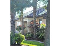 Charming single-story home with stucco exterior, tile roof, and landscaped front yard with mature trees at 213 Babbling Brook Run, Bradenton, FL 34212