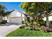 Charming home featuring a two-car garage, beautiful landscaping, and a brick-paved walkway to the front door at 2397 Vaccaro Dr, Sarasota, FL 34231