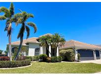 Inviting single-story home featuring lush landscaping, a clay tile roof, and a two-car garage at 2980 Seasons Blvd, Sarasota, FL 34240