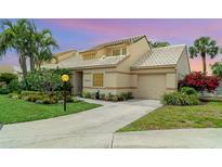 Charming home featuring lush landscaping, a well-manicured lawn, and an attached garage at 3609 57Th Avenue W Dr # 37, Bradenton, FL 34210