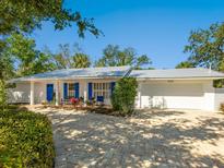 Charming single-story home with a metal roof, lovely landscaping, and a brick driveway at 5432 Cape Leyte Dr, Sarasota, FL 34242