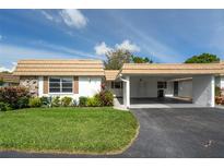 Charming home featuring a covered carport, stone accents, and well-maintained landscaping at 5521 Riverbluff Cir # V-10, Sarasota, FL 34231