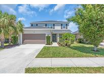 Charming two-story home boasts a well-manicured lawn, lush landscaping, and an attached two-car garage at 5740 Sunflower Cir, Sarasota, FL 34238