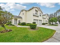 Charming townhome featuring a well-manicured lawn, attached garage, and neutral stucco exterior on a beautiful sunny day at 6330 Green Oak Cir, Bradenton, FL 34203