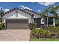 Charming single-story home featuring a brick driveway, a two-car garage, and professionally landscaped front yard at 6713 Chester Trl, Bradenton, FL 34202