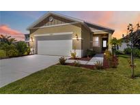 Charming home features a well-manicured lawn, a two-car garage and a welcoming entryway at 10455 Wet Marsh Cv, Parrish, FL 34219