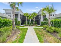 Inviting exterior view of condo with landscaped walkway, palm trees and screened lanais at 14184 Heritage Landing Blvd # 513, Punta Gorda, FL 33955