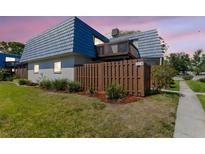 Charming townhome featuring a unique roofline, second story balcony, and well-maintained landscaping at 14519 Catalina Cir, Seminole, FL 33776