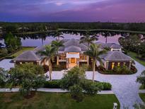 Luxury estate with beautiful landscaping, paver driveway and lake view at dusk at 18826 Ganton Ave, Lakewood Ranch, FL 34202