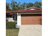 Charming single-story home featuring a red tile roof, stone accents, a well-maintained yard, and an attached two-car garage at 3209 Riviera Dr, Sarasota, FL 34232
