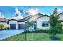 Charming single-Gathering home with a manicured lawn, gray exterior, well-kept landscaping, and a paved driveway at 4970 Oyster Pearl St, Lakewood Ranch, FL 34211