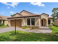 Charming single-story home with a tile roof, lush landscaping, and a welcoming front entrance at 5624 Aaron Ct, Sarasota, FL 34232