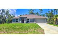 Charming single-story home with lush lawn, gray exterior, and a two car garage at 5672 Jonesboro Ave, North Port, FL 34288