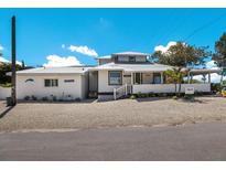 Charming single-Gathering home features white exterior, metal roof, and inviting front porch, near the beach at 601 Gulf S Dr, Bradenton Beach, FL 34217