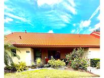 Charming villa with a well-maintained lawn, vibrant flowers, and a distinctive terracotta roof at 6368 Draw Ln # 34, Sarasota, FL 34238
