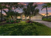 Charming single-story home with a well-manicured lawn, mature landscaping, and a brick-paved driveway at 7574 Camden Harbour Dr, Bradenton, FL 34212