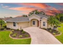 Inviting home with well-manicured lawn, mature palms, and colorful sunset backdrop at 9101 Yarberry St, Sarasota, FL 34240