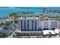 Stunning aerial view of the waterfront condominium building with boat docks and open ocean in the background at 101 S Gulfstream Ave # 5J, Sarasota, FL 34236
