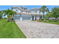 Beautiful two-story home with a three-car garage and a well-manicured lawn at 11913 Blue Hill Trl, Bradenton, FL 34211