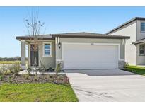 Charming single-story home featuring a large white garage door and neutral colored exterior paint at 14061 Crutchfield Ct, Parrish, FL 34219