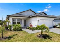 Beautifully landscaped single-Gathering home with lush greenery and a paved walkway leading to the front door at 16849 Castoro Dr, Port Charlotte, FL 33953