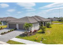 Beautiful single-story home with a well-manicured lawn and a two-car garage in a sunny location at 2072 Mackerel St, Port Charlotte, FL 33953