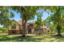 Charming two-story home with a well-manicured lawn and mature trees in a serene outdoor setting at 222 High Point Dr, Venice, FL 34292