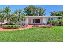 Charming single-story home featuring a well-manicured lawn and colorful floral landscaping at 2425 Calamonga Ln, Sarasota, FL 34239