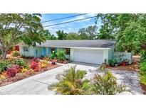 Well landscaped single Gathering home with a two car garage and baby blue shutters on this charming home at 3036 Rose St, Sarasota, FL 34239