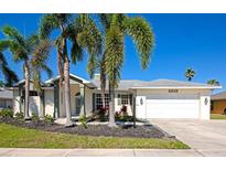 Charming single Gathering home featuring a two-car garage, lush landscaping, and curb appeal at 4092 Green Tree Ave, Sarasota, FL 34233