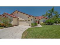 Charming home with a well-maintained lawn, red tile roof, and attached two car garage at 4691 Las Brisas Ln, Sarasota, FL 34238