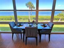 Dining area boasts stunning water views through large windows, creating a serene dining experience at 4800 Gulf Of Mexico Dr # 205, Longboat Key, FL 34228
