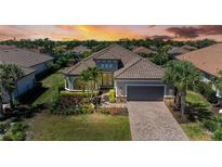 Beautiful home featuring a tile roof, landscaped yard, and a brick driveway leading to a two-car garage at 4908 Tivoli Run, Bradenton, FL 34211