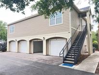 Beige two story condo with white doors, black railings, and three garages at 5741 Soldier Cir # 202, Sarasota, FL 34233